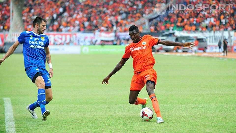 Pemain Persija, Eddie Foday Boakay, berusaha mengontrol bola dibawah kawalan pemain Persib Vladimir Vujovic. 